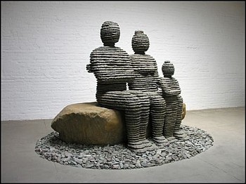Boaz Vaadia The Family (#100) (2008), a large-scale bronze and bluestone figurative sculpture featuring three seated human figures resting on a boulder, measuring 74 x 115 x 115 inches. This stacked stone artwork merges ancient techniques with modern abst