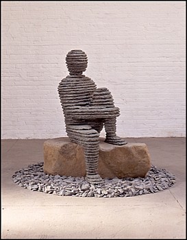 Boaz Vaadia Eli'av (1997), a bronze and bluestone sculpture depicting a seated human figure on a natural boulder, surrounded by stones. This modern figurative stone sculpture exemplifies Vaadiaâ€™s distinct artistic approach. Available at Sponder Gallery.