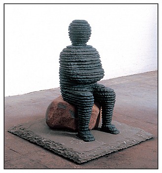 Boaz Vaadia Ba'al (#32) (1996), a bronze and bluestone sculpture of a seated figure atop a natural boulder, created using stacked-stone artistry. A striking contemporary sculpture available at Sponder Gallery.
